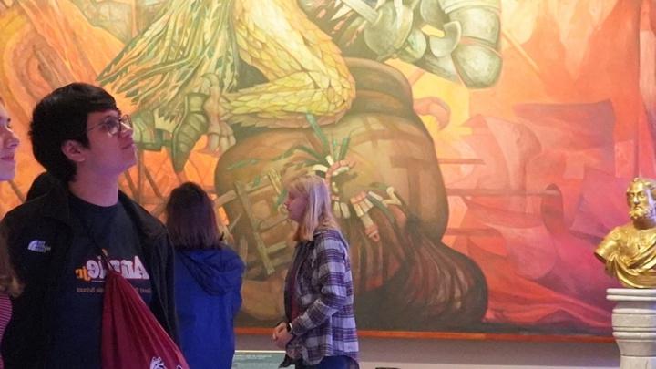 澳门金沙线上赌博官网的学生在画廊审阅一件大型艺术品.